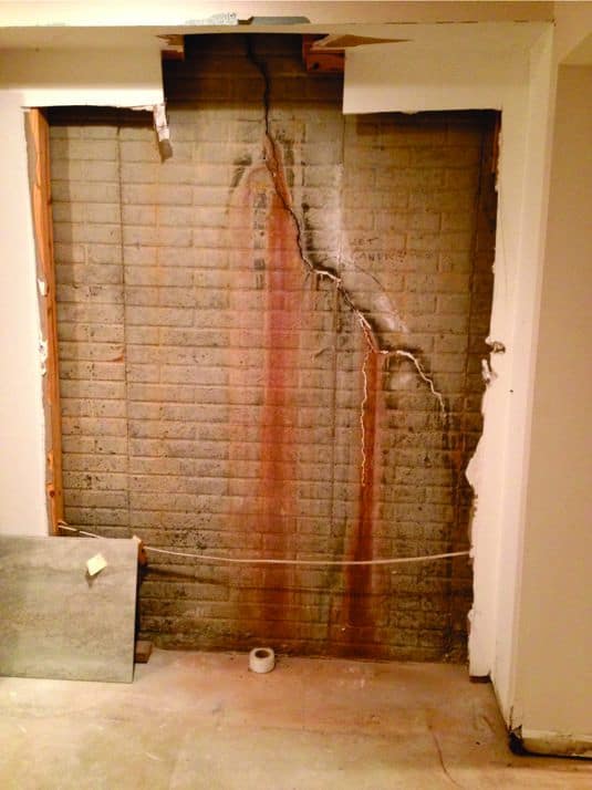 Below-grade perimeter wall of a Hollywood Hills residence showing water intrusion and crack damage.