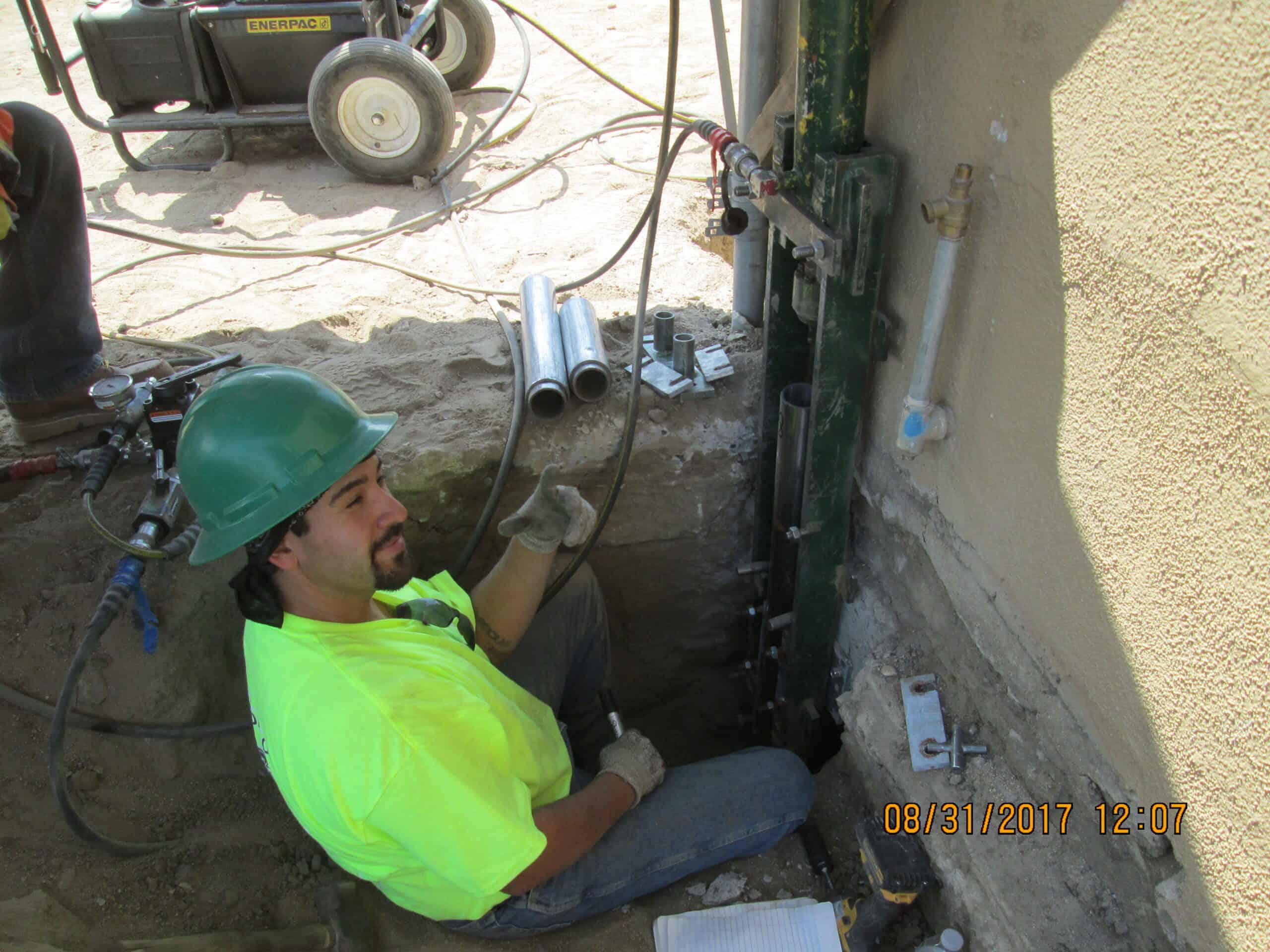Installing a push pier for foundation repair.